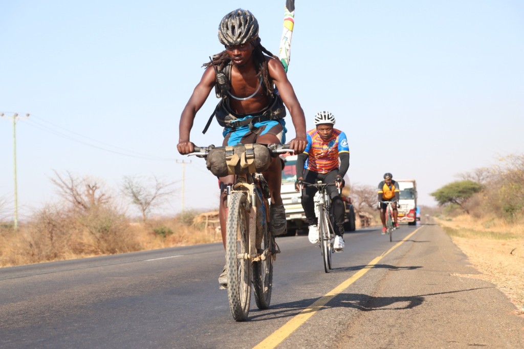 Determined cyclists riding on a rural road through arid landscape