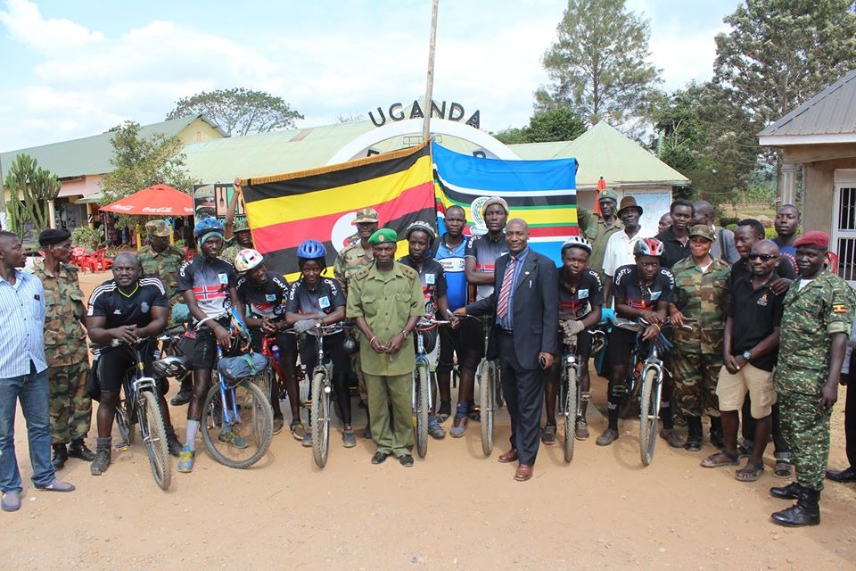 Cyclists welcomed at the Uganda border with military escort and national flags